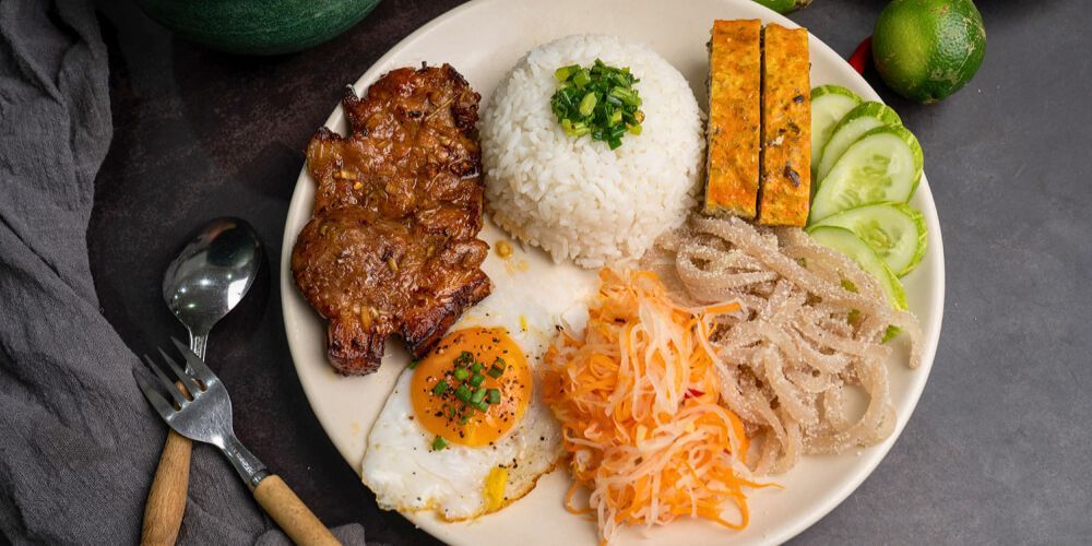 Broken rice is typically served on a flat plate or in a bowl, with the broken rice placed as the base